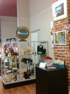 The interior of the gift shop showing items on display on shelves and artsworks on the walls
